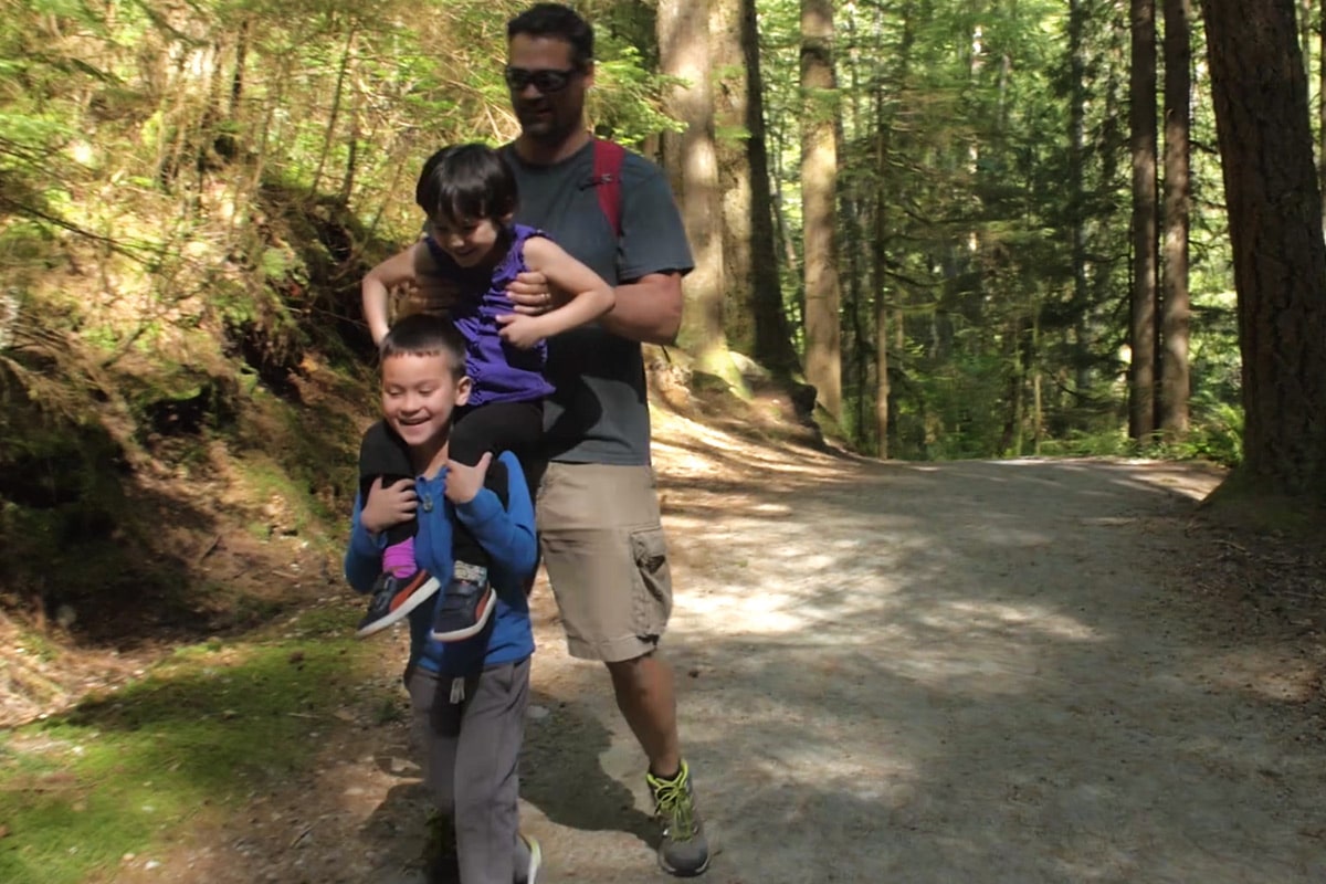 Dad teaching son to skateboard and be active outdoors