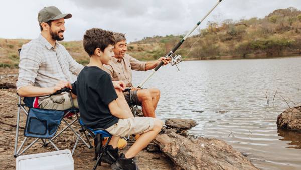 father, son, and grandfather outside fishing together