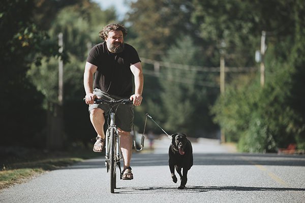 Toby Hargrave riding his bike and running the dog at the same time