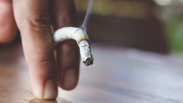 limp cigarette between two fingers