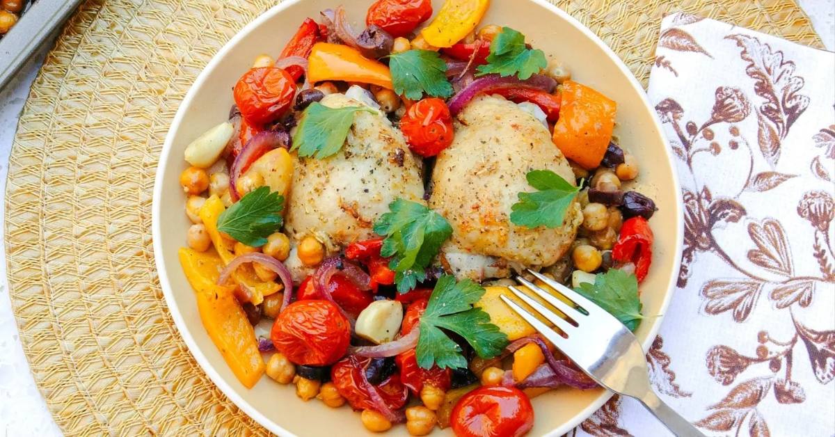 plate of roasted chicken with veggies and a fork